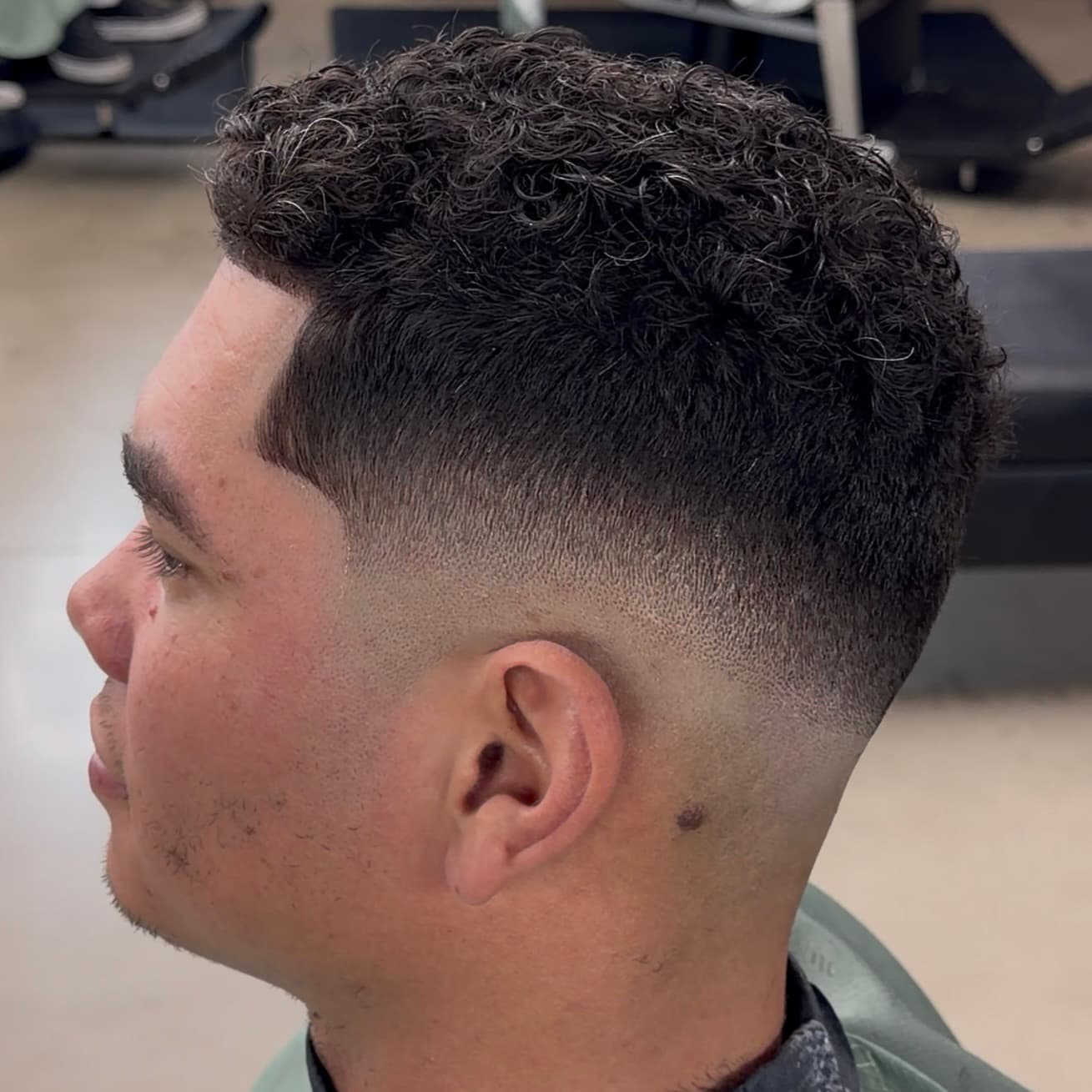 Curly top with clean mid fade by Mike Drop Fades in Cypress TX